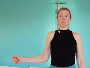 Dr. chloe demonstrating an external rotation rotator cuff exercise by bringing her right arm that is bent at a 90 degree angle, elbow by her side out to the side